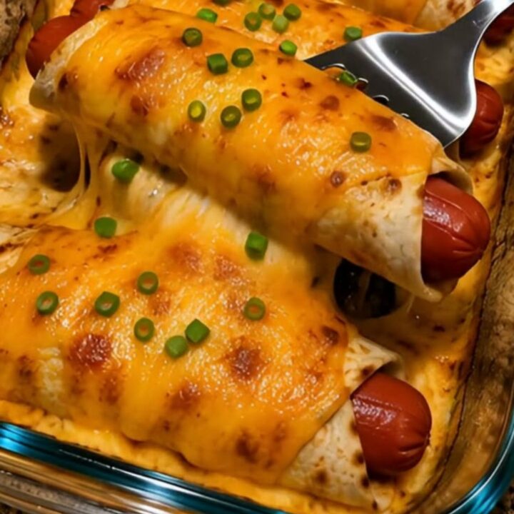 A close-up of a cheesy hot dog tortilla melt showing a dramatic cheese pull with bubbly cheddar and green onions.