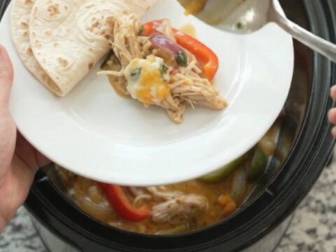 Creamy Crockpot fajita chicken with shredded chicken, peppers, and onions in a creamy sauce