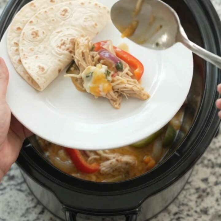 Creamy Crockpot fajita chicken with shredded chicken, peppers, and onions in a creamy sauce