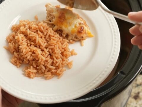 Slow cooker filled with shredded chicken, peppers, and melted Oaxaca cheese