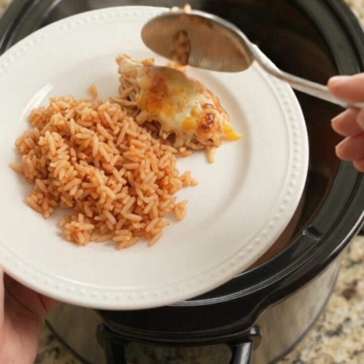 Slow cooker filled with shredded chicken, peppers, and melted Oaxaca cheese