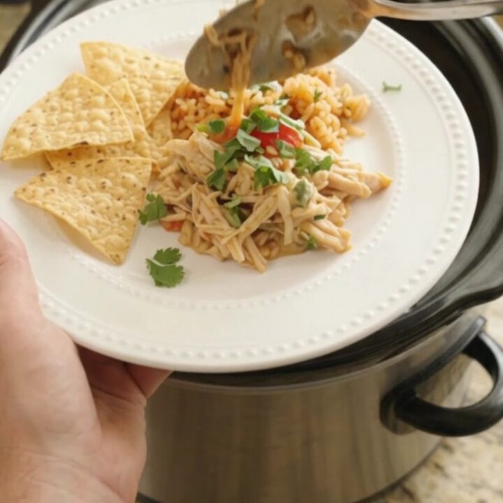 Shredded chicken with peppers and onions in a creamy cheese sauce in a slow cooker