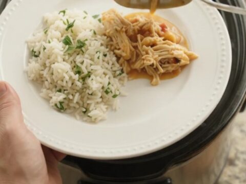 Slow cooker fiesta chicken with creamy chipotle pineapple sauce, topped with melted cheddar