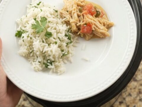 Crockpot with creamy cheddar jalapeño fiesta chicken, bubbling and steaming