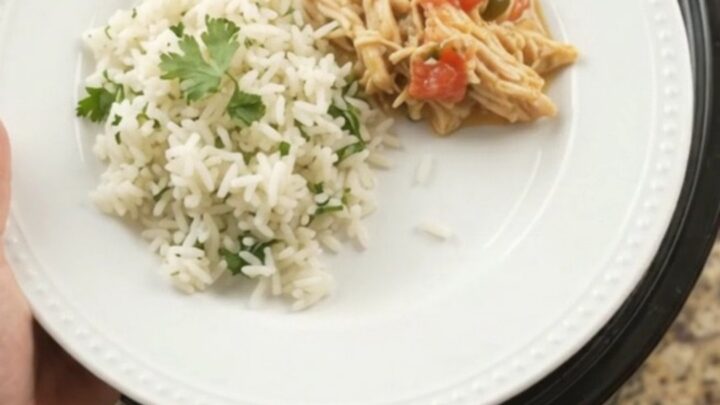 Crockpot with creamy cheddar jalapeño fiesta chicken, bubbling and steaming