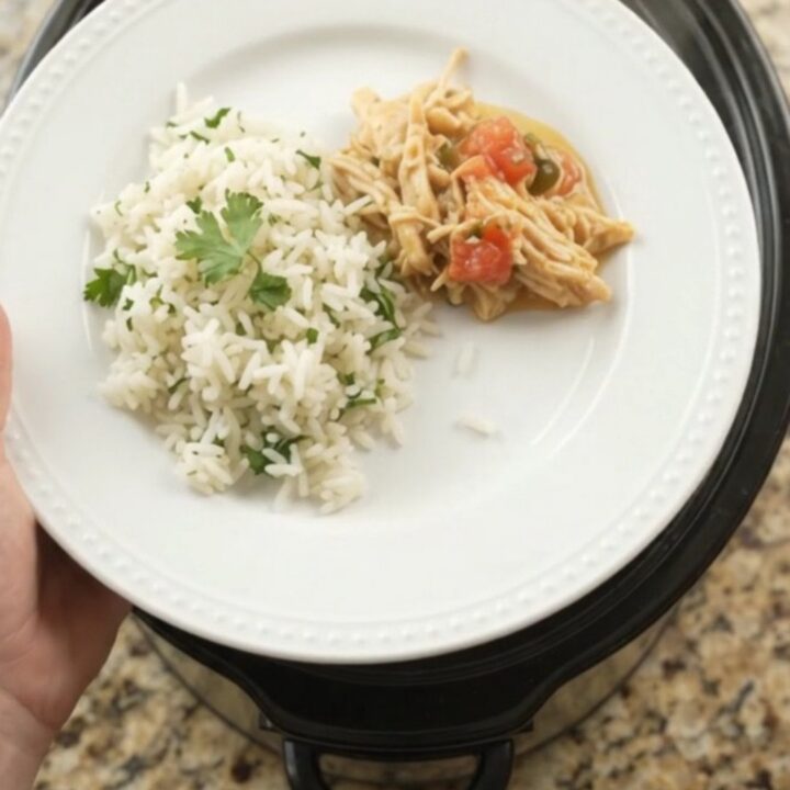 Crockpot with creamy cheddar jalapeño fiesta chicken, bubbling and steaming