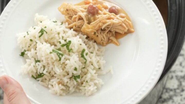 Crockpot fiesta chicken with creamy cheese sauce, shredded chicken, and pinto beans in a slow cooker.