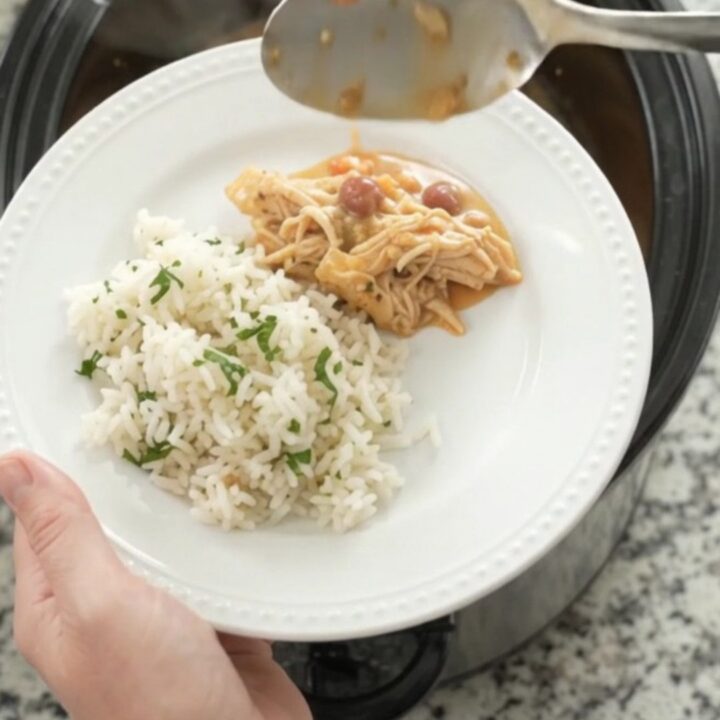 Crockpot fiesta chicken with creamy cheese sauce, shredded chicken, and pinto beans in a slow cooker.