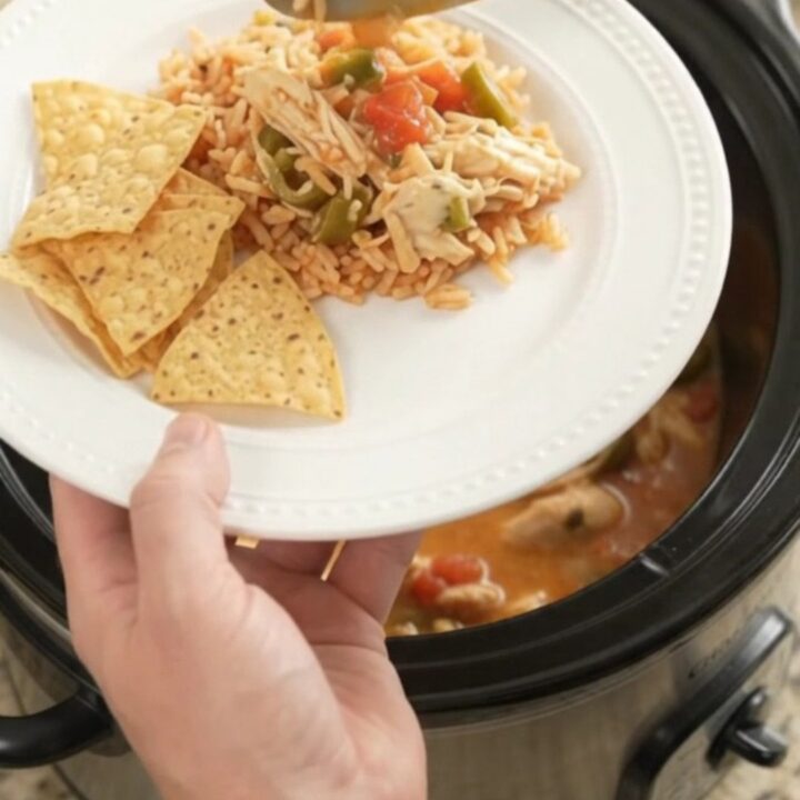 Shredded fiesta chicken in a creamy pepper jack and queso sauce in a slow cooker