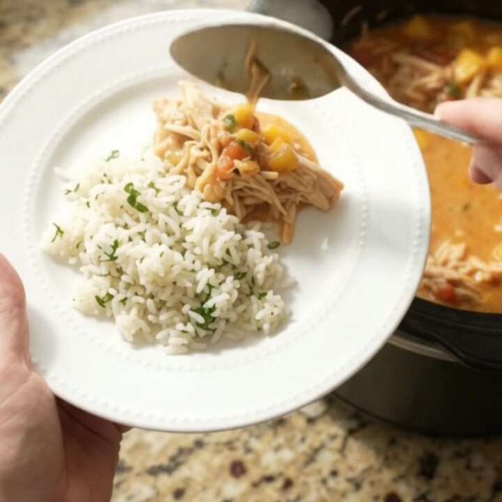 Slow cooker fiesta chicken with creamy cheddar and mango, served in a black crockpot