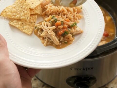 Slow cooker filled with shredded chicken in a creamy mango habanero cheese sauce, garnished with cilantro.