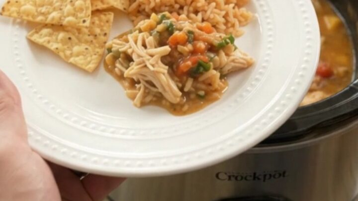 Slow cooker filled with shredded chicken in a creamy mango habanero cheese sauce, garnished with cilantro.