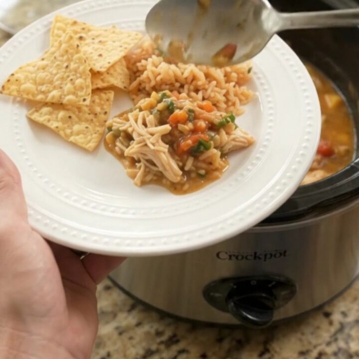 Slow cooker filled with shredded chicken in a creamy mango habanero cheese sauce, garnished with cilantro.
