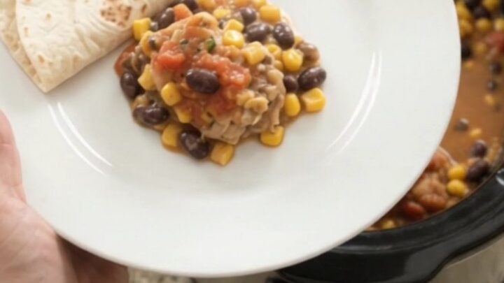 Slow cooker filled with creamy chicken, black beans, corn, and melted Monterey Jack cheese