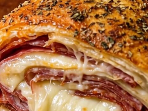 A golden-brown, crispy Italian stromboli cut into thick slices
