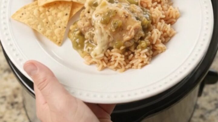 Slow cooker filled with shredded chicken in creamy salsa verde and melted cheese, topped with cilantro.