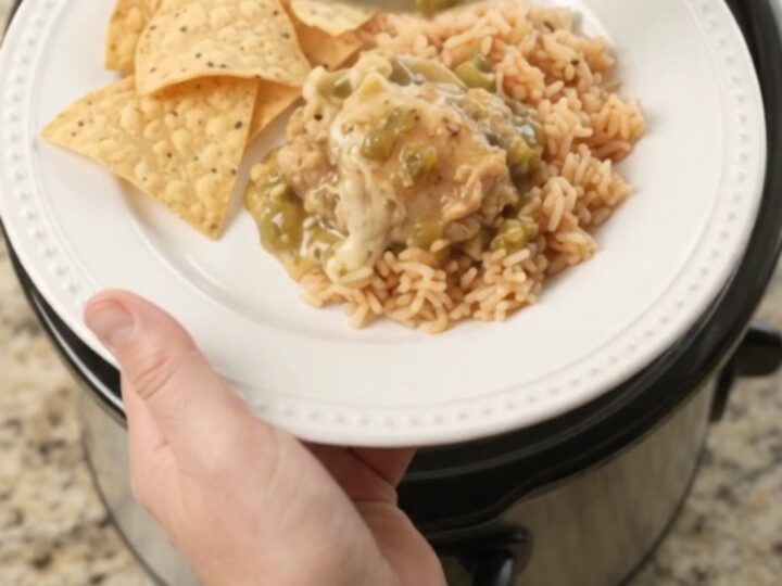 Slow cooker filled with shredded chicken in creamy salsa verde and melted cheese, topped with cilantro.
