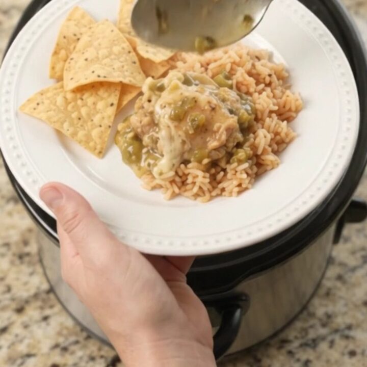 Slow cooker filled with shredded chicken in creamy salsa verde and melted cheese, topped with cilantro.