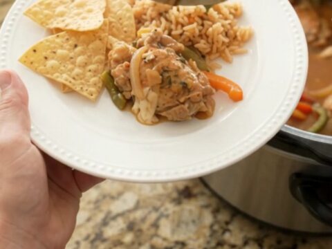 Slow cooker chicken thighs in creamy pepper jack queso sauce with bell peppers and onions
