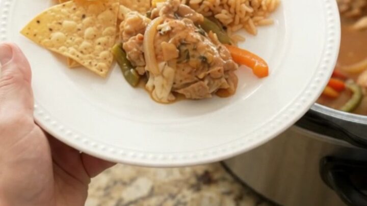 Slow cooker chicken thighs in creamy pepper jack queso sauce with bell peppers and onions