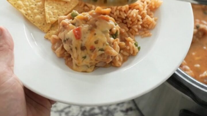 Slow cooker filled with bubbling chipotle pineapple chicken thighs in creamy pepper jack queso sauce