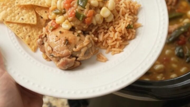 Bubbling slow cooker filled with chicken thighs, hominy, and melted pepper jack queso sauce.