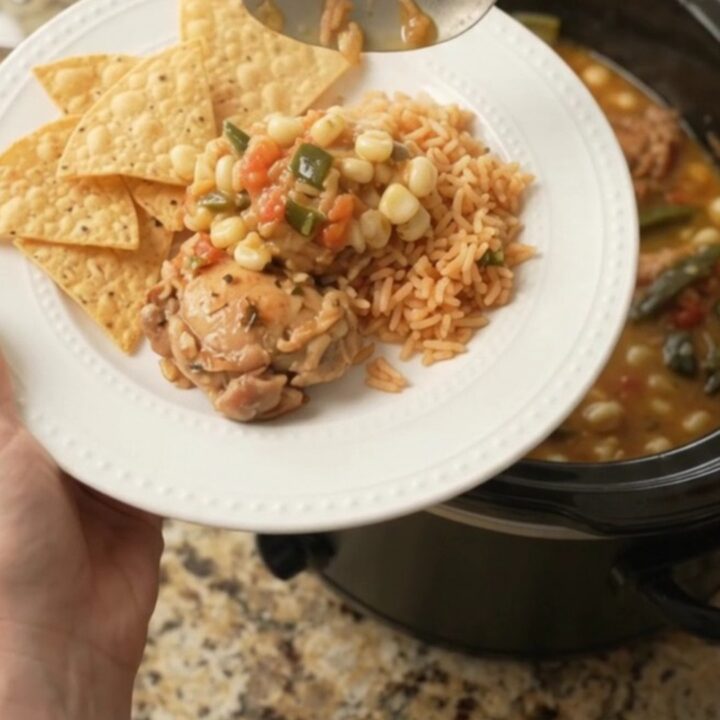Bubbling slow cooker filled with chicken thighs, hominy, and melted pepper jack queso sauce.