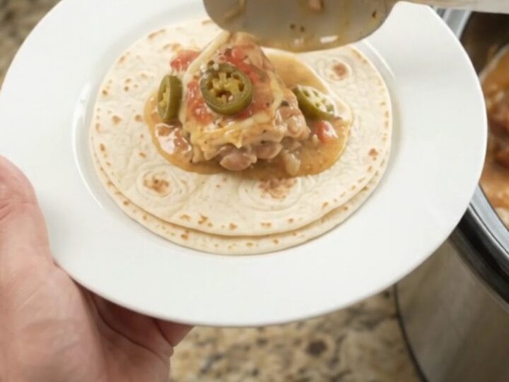 Slow cooker chicken thighs in creamy tomato-jalapeño sauce with melted cheese