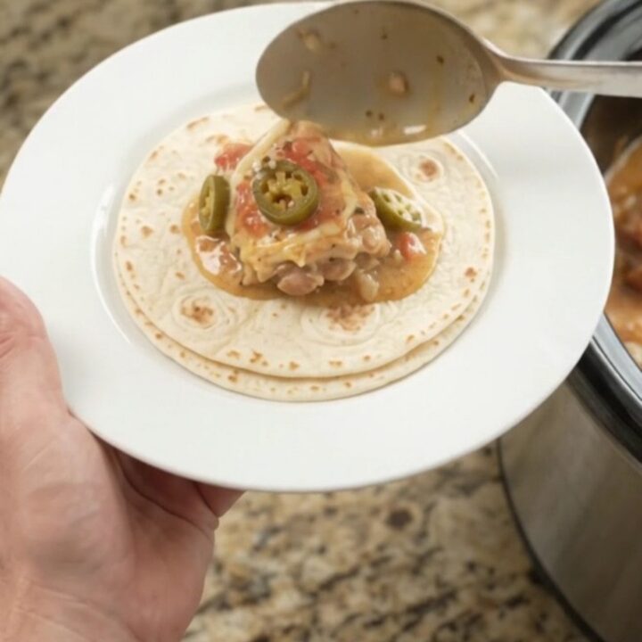 Slow cooker chicken thighs in creamy tomato-jalapeño sauce with melted cheese