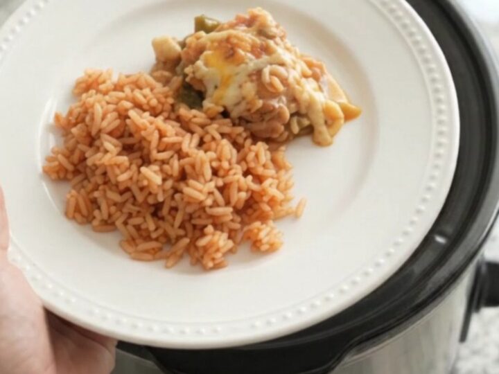 Slow cooker filled with cheesy chicken and hominy stew, bubbling with melted Oaxaca cheese