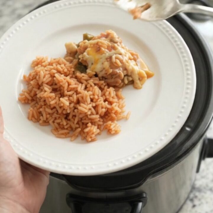Slow cooker filled with cheesy chicken and hominy stew, bubbling with melted Oaxaca cheese