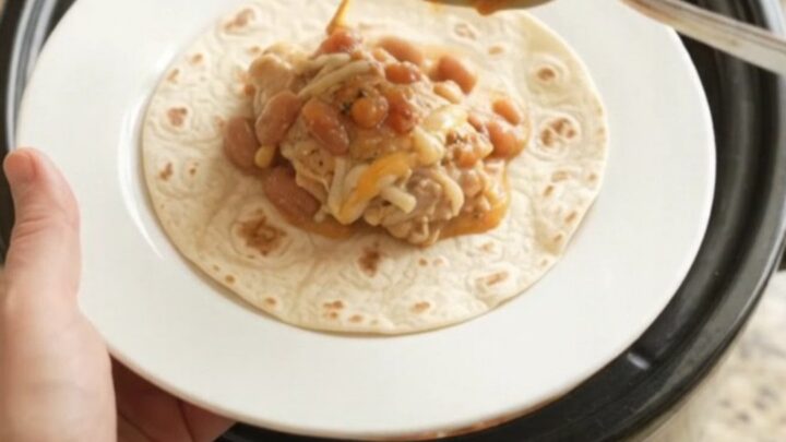 Slow cooker chicken thighs with pinto beans and melted Monterey Jack cheese, served with warm tortillas
