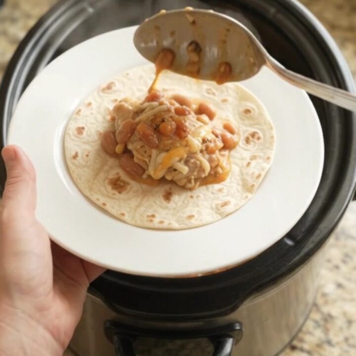 Slow cooker chicken thighs with pinto beans and melted Monterey Jack cheese, served with warm tortillas