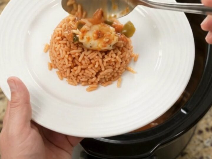 Slow cooker filled with shredded chicken in a cheesy tomato-jalapeño sauce, topped with melted Oaxaca cheese.