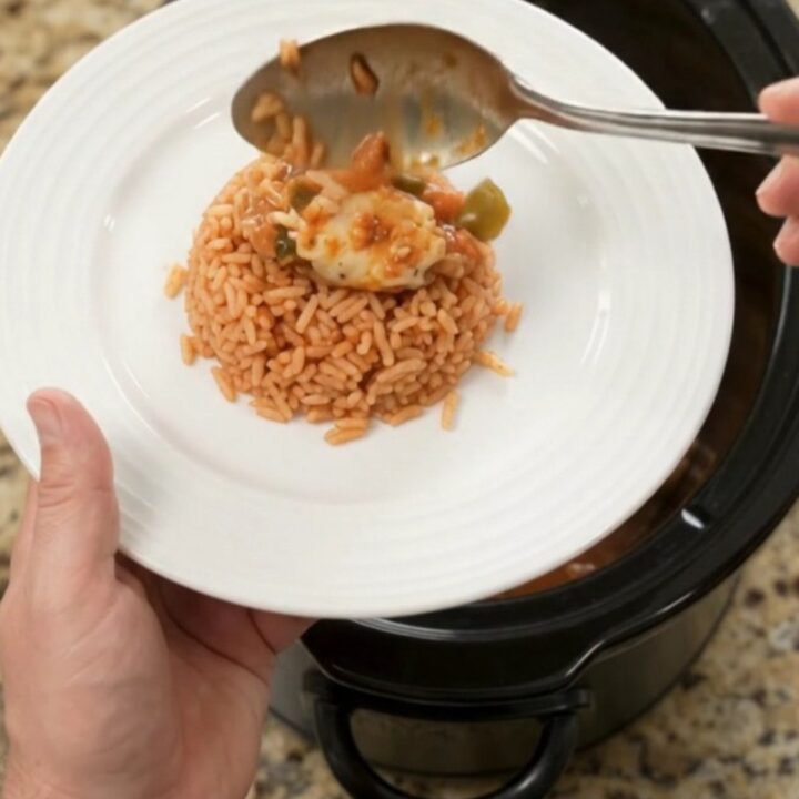 Slow cooker filled with shredded chicken in a cheesy tomato-jalapeño sauce, topped with melted Oaxaca cheese.
