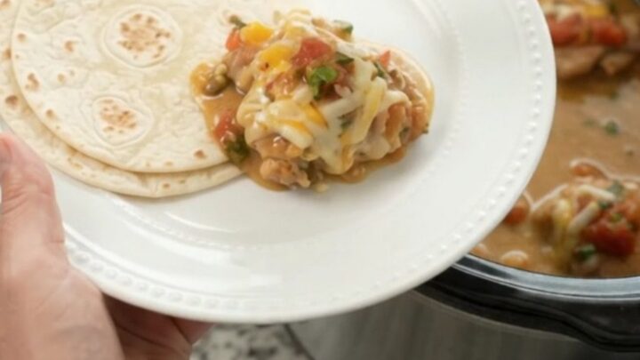 Slow cooker filled with creamy mango habanero chicken and melted cheese