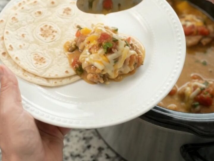 Slow cooker filled with creamy mango habanero chicken and melted cheese