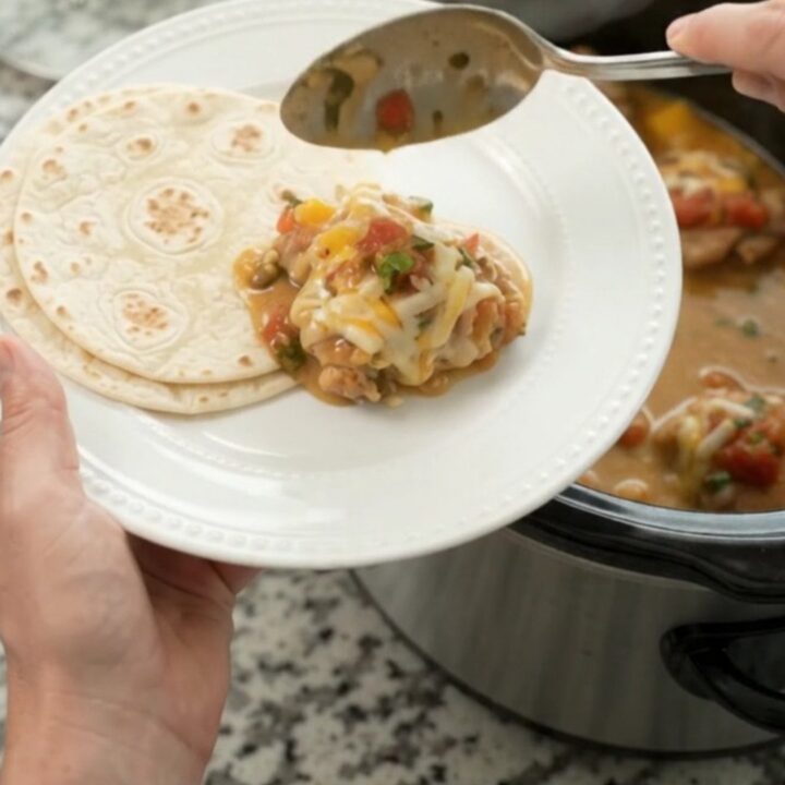 Slow cooker filled with creamy mango habanero chicken and melted cheese