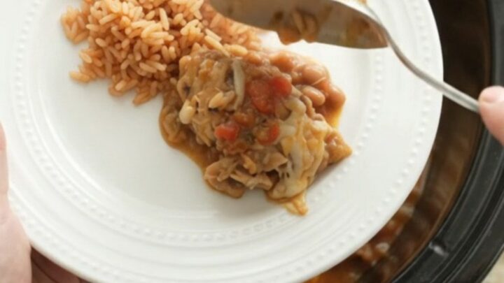 Slow cooker filled with shredded chicken, beans, and melted Oaxaca cheese, topped with blistered cheese.