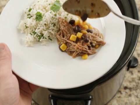 Slow cooker beef barbacoa with black beans, corn, and melted cheese sauce