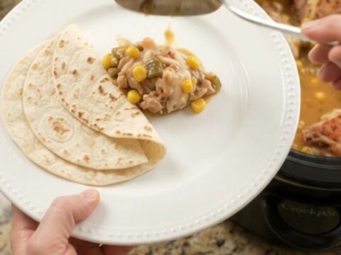 Bubbling creamy chicken thighs with green chiles and corn in a slow cooker