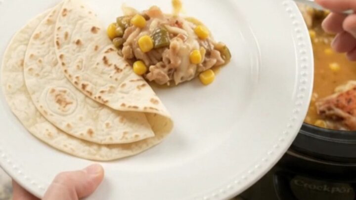 Bubbling creamy chicken thighs with green chiles and corn in a slow cooker