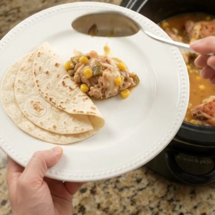 Bubbling creamy chicken thighs with green chiles and corn in a slow cooker