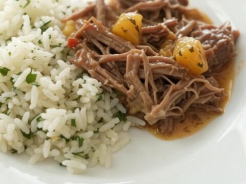 Crockpot full of shredded beef barbacoa in creamy chipotle cheddar sauce with pineapple