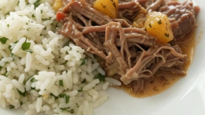 Crockpot full of shredded beef barbacoa in creamy chipotle cheddar sauce with pineapple