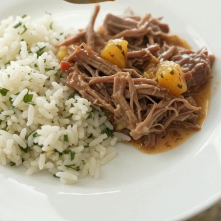 Crockpot full of shredded beef barbacoa in creamy chipotle cheddar sauce with pineapple