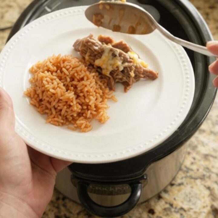 Slow cooker filled with shredded beef barbacoa topped with melted cheese and pineapple