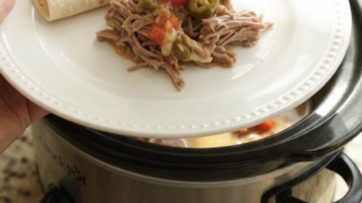 Slow cooker beef barbacoa with creamy tomato-jalapeño sauce in a black crockpot