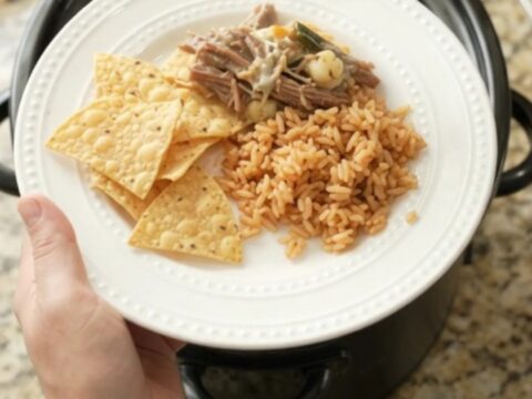 Shredded beef barbacoa with poblano and hominy in creamy queso sauce in a slow cooker