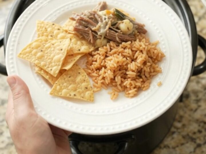 Shredded beef barbacoa with poblano and hominy in creamy queso sauce in a slow cooker